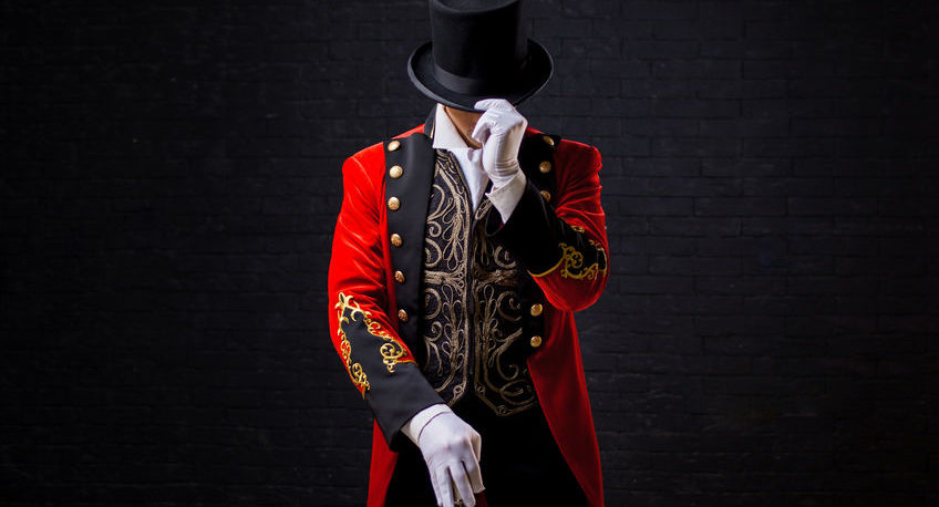 showman. young male entertainer, presenter or actor on stage. the guy in the red camisole and the cylinder.